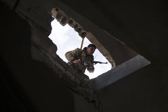 Ein Kämpfer der von den USA unterstützten Syrischen Demokratischen Kräfte durchsucht ein Gebäude in Baghus.