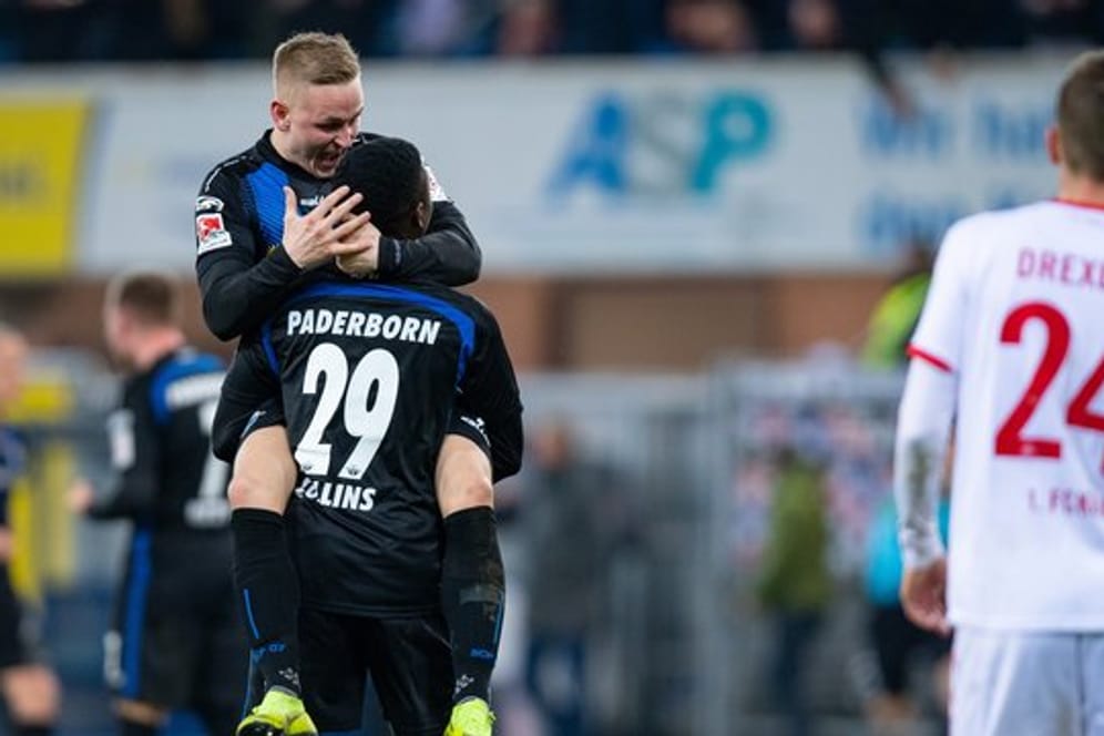 Die Paderborner Kai Pröger (l) und Jamilu Collins feiern den Sieg über den 1.