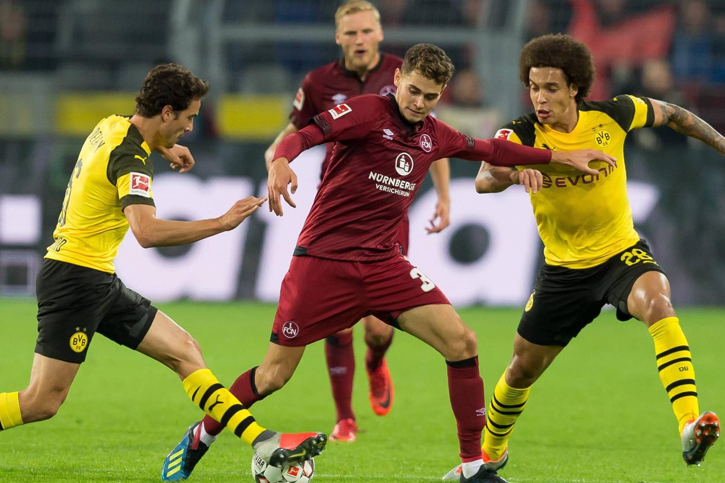 Dortmunds Thomas Delaney (l.), und Axel Witsel nehmen Nürnbergs Alexander Fuchs (M.) in die Zange.