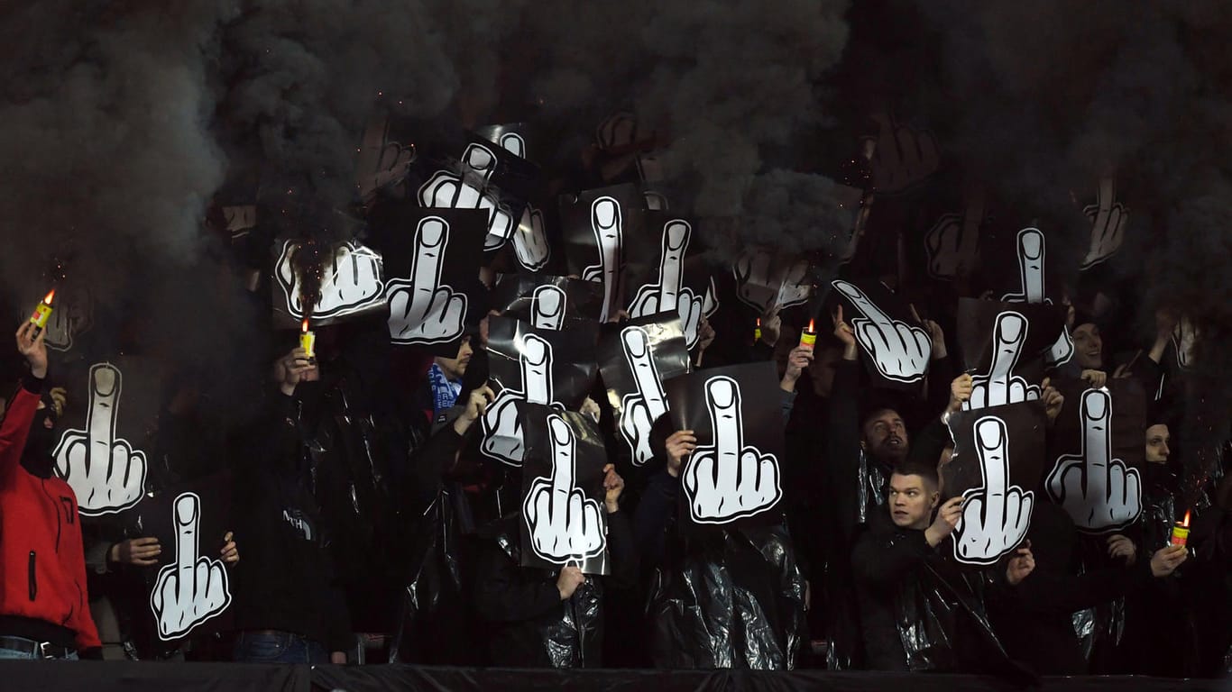 Während der Partie gegen Dortmund: Anhänger des 1. FC Nürnberg zünden Pyrotechnik und zeigen Plakate mit Mittelfingern.