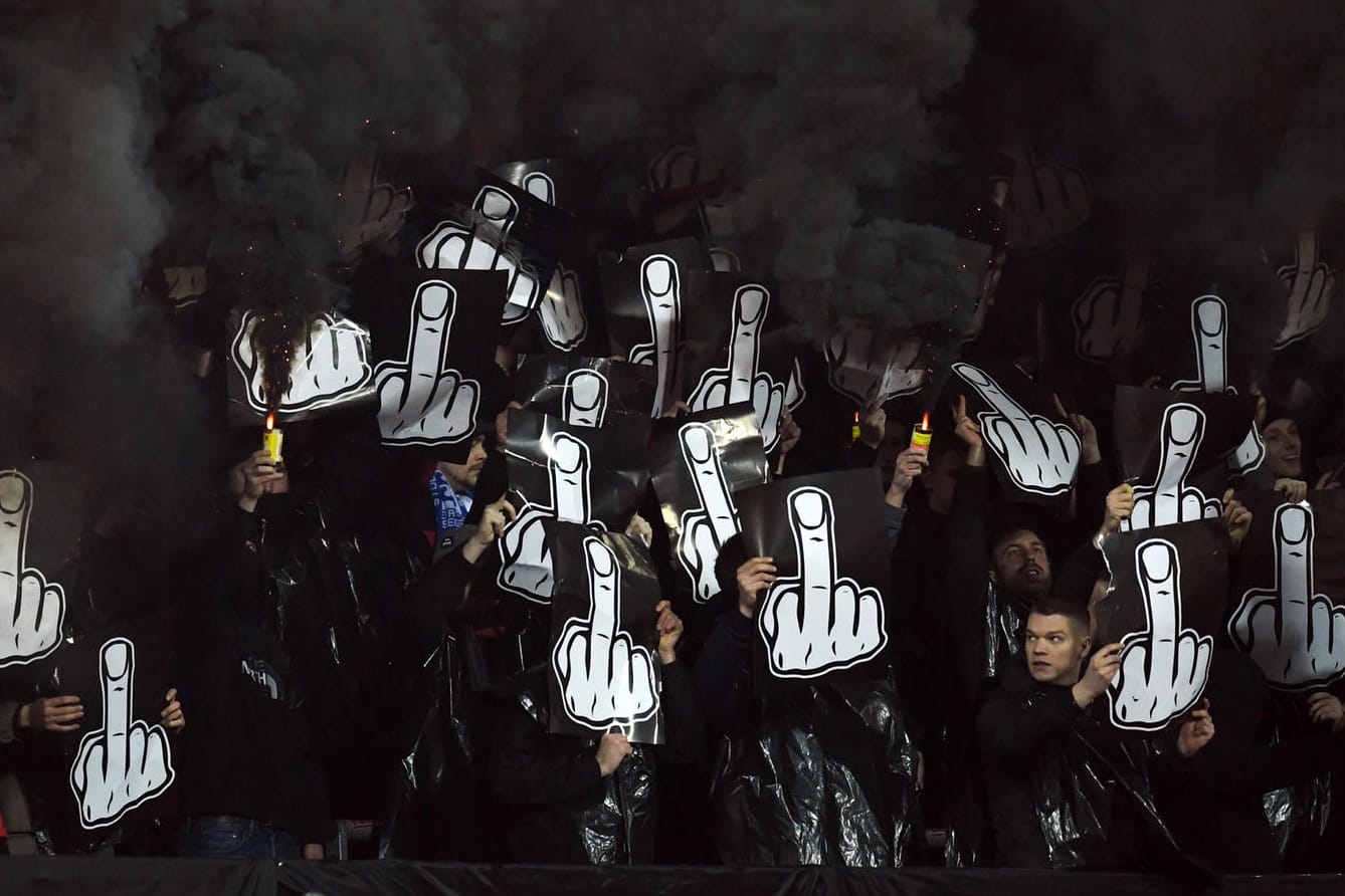 Während der Partie gegen Dortmund: Anhänger des 1. FC Nürnberg zünden Pyrotechnik und zeigen Plakate mit Mittelfingern.