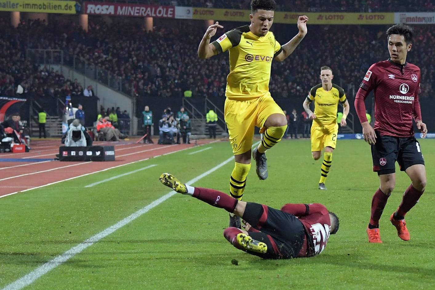 Stellvertretend für eine intensive Partie: Nürnbergs Tim Leibold (u.) grätscht mit vollem Einsatz den Ball vor dem herannahenden Dortmunder Jadon Sancho ins Aus.