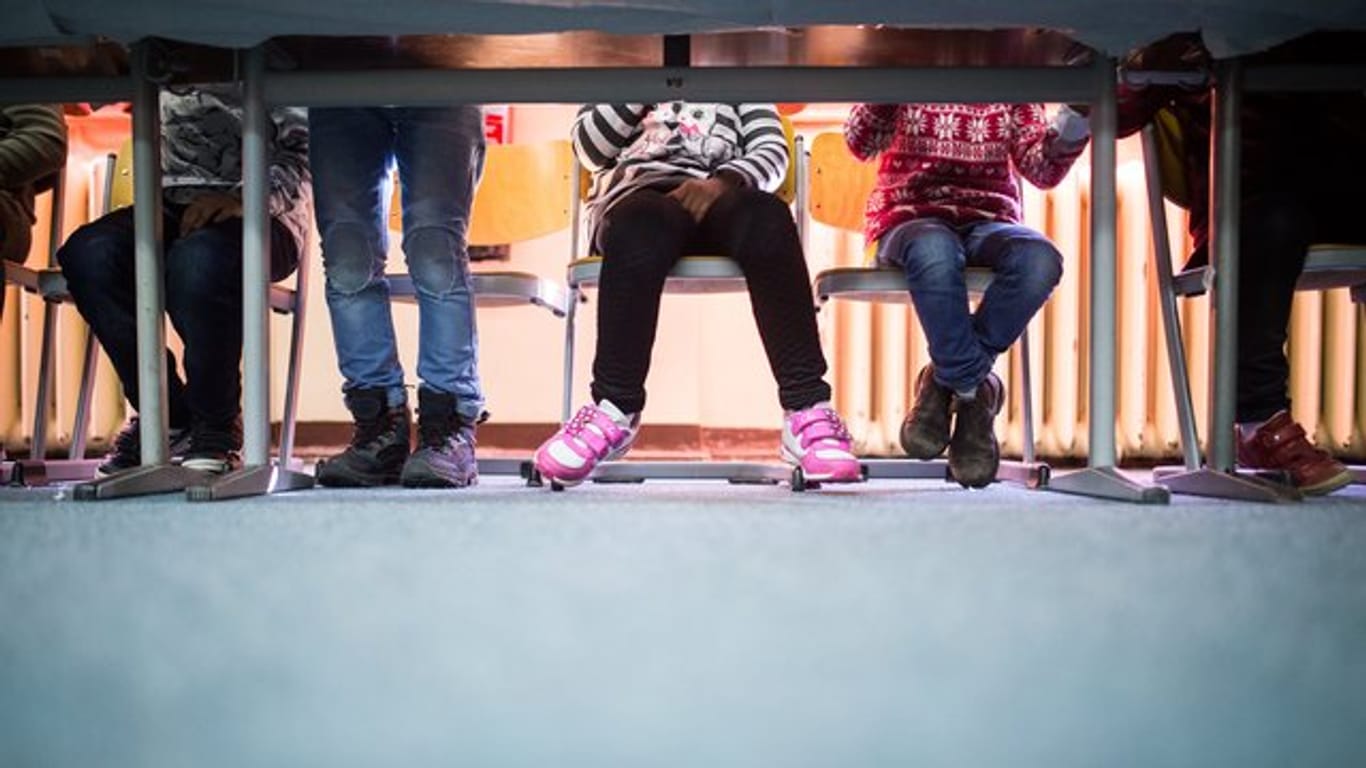 Kinder sitzen an einem Tisch: Im Schulalter erkranken viele Kinder an Depressionen.
