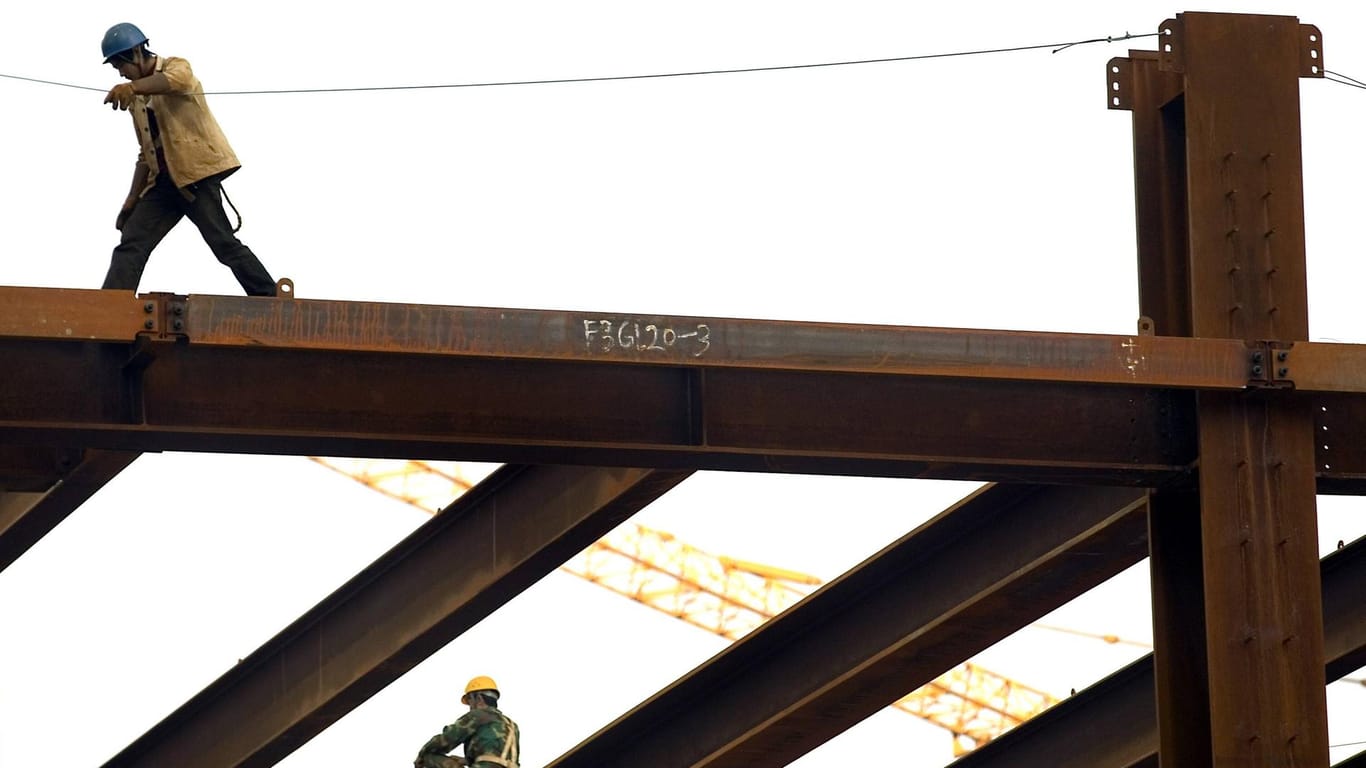 Bauarbeiter auf Stahlskelett eines Gebäudes (Symboldbild): In Leipzig ist ein Betonbauer bei einem Arbeitsunfall unter einem 20 Meter langen Stahlträger eingeklemmt worden.