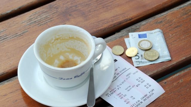 Kaffeetasse mit Rechnung und Geld Kaffeetasse mit Rechnung und Geld