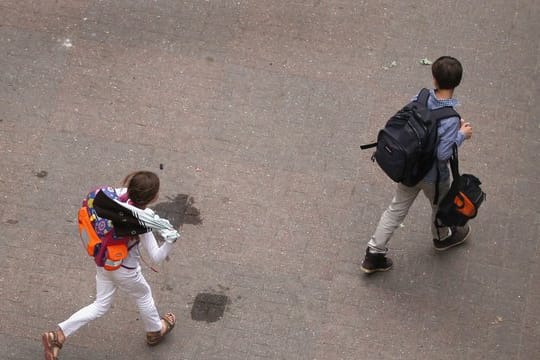Zwei Schüler gehen über den Hof einer Schule.