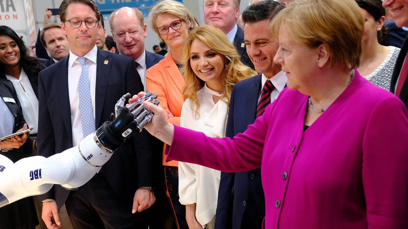Angela Merkel schüttelt Hände mit einem Roboter: Im November hat die Bundesregierung ihre KI-Strategie vorgelegt.