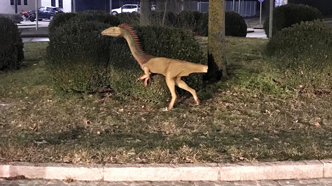 Bayern, Abensberg: Das am Schwanz beschädigte Modell eines Dinosauriers "Coelophysis" steht an einem Kreisverkehr im Landkreis Kelheim.