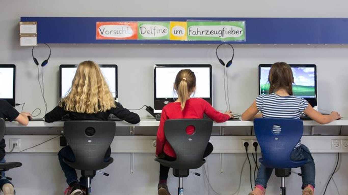 Schülerinnen arbeiten im Klassenraum einer Grundschule an Computern.