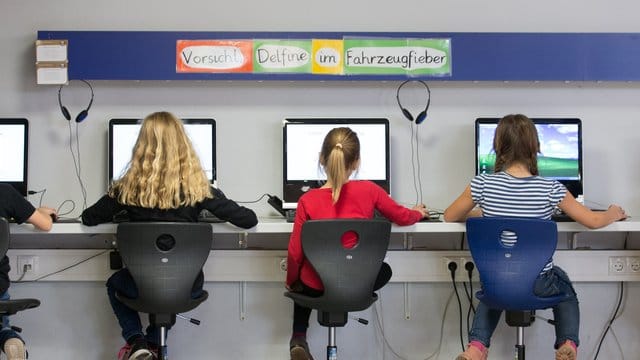 Schülerinnen arbeiten im Klassenraum einer Grundschule an Computern.