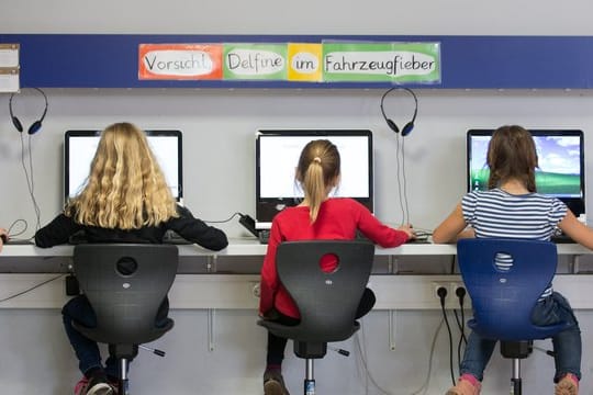 Schülerinnen arbeiten im Klassenraum einer Grundschule an Computern.