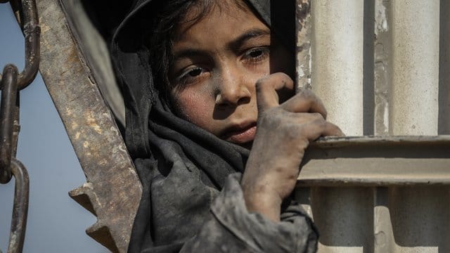Ein Kind fährt auf einem Lastwagen, der Zivilisten und Familienangehörige von IS-Kämpfern aus der letzten Bastion der Terrormiliz im ostsyrischen Baghus in ein Zwischenlager bringt. Ein Kind fährt auf einem Lastwagen, der Zivilisten und Familienangehörige von IS-Kämpfern aus der letzten Bastion der Terrormiliz im ostsyrischen Baghus in ein Zwischenlager bringt.