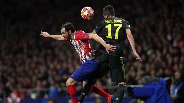 Atleticos Juanfran Torres (l) und Juve-Stürmer Mario Mandzukic kämpfen um den Ball.