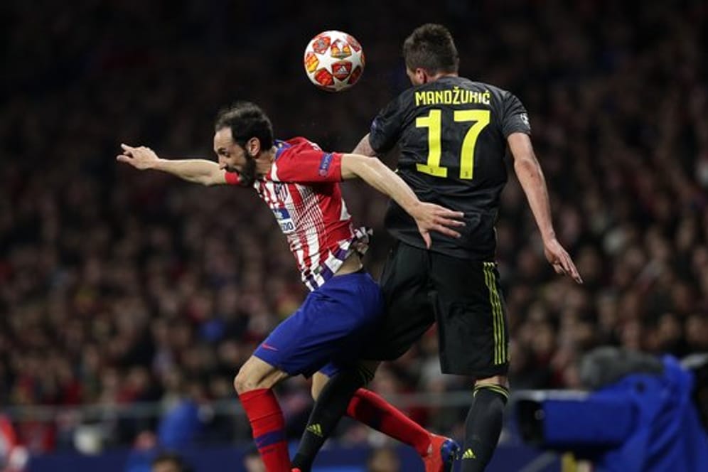 Atleticos Juanfran Torres (l) und Juve-Stürmer Mario Mandzukic kämpfen um den Ball.