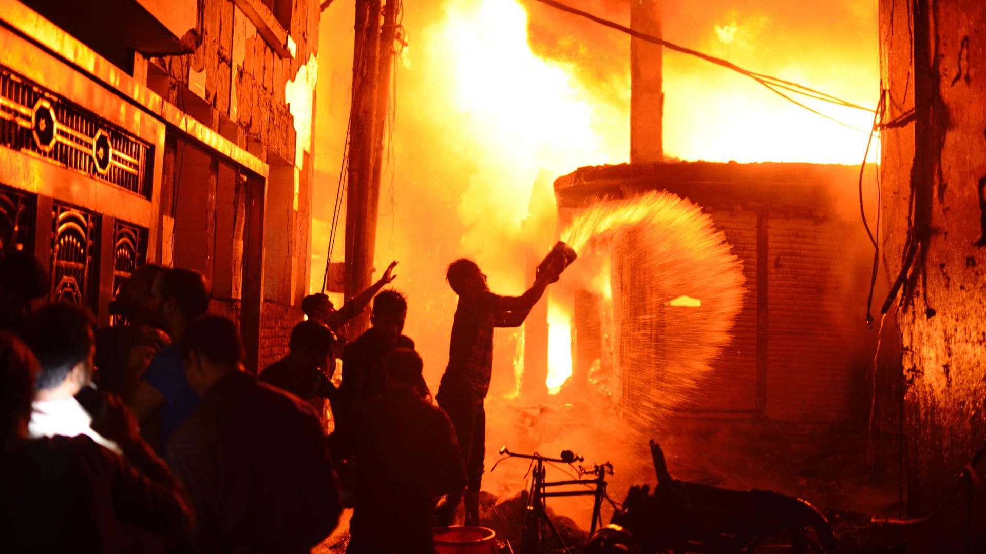 Feuerwehr und Anwohner versuchen einen Brand in Dhaka zu löschen: Bei einem Großbrand in Bangladeschs Hauptstadt Dhaka sind dutzende Menschen ums Leben gekommen. Feuerwehr und Anwohner versuchen einen Brand in Dhaka zu löschen: Bei einem Großbrand in Bangladeschs Hauptstadt Dhaka sind dutzende Menschen ums Leben gekommen.