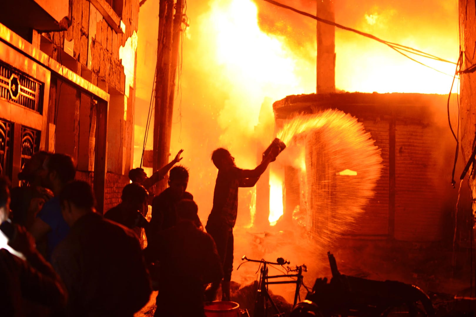 Feuerwehr und Anwohner versuchen einen Brand in Dhaka zu löschen: Bei einem Großbrand in Bangladeschs Hauptstadt Dhaka sind dutzende Menschen ums Leben gekommen.