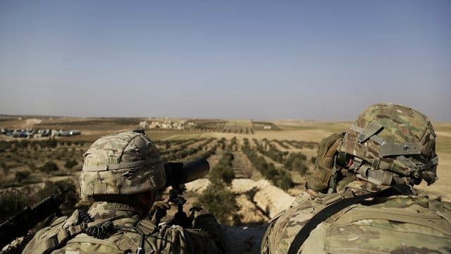 Zwei US-Soldaten schauen von ihrer Basis in Syrien zur türkischen Grenze hinüber. Zwei US-Soldaten schauen von ihrer Basis in Syrien zur türkischen Grenze hinüber.