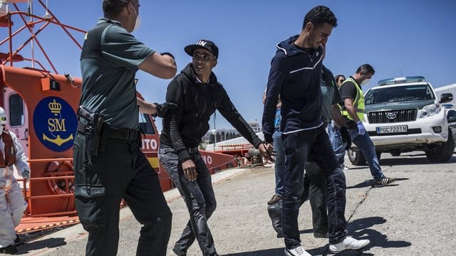 Zwei Migranten aus Nordafrika kommen nach ihrer Rettung in der Straße von Gibraltar im Hafen von Tarifa in Spanien an. Zwei Migranten aus Nordafrika kommen nach ihrer Rettung in der Straße von Gibraltar im Hafen von Tarifa in Spanien an.