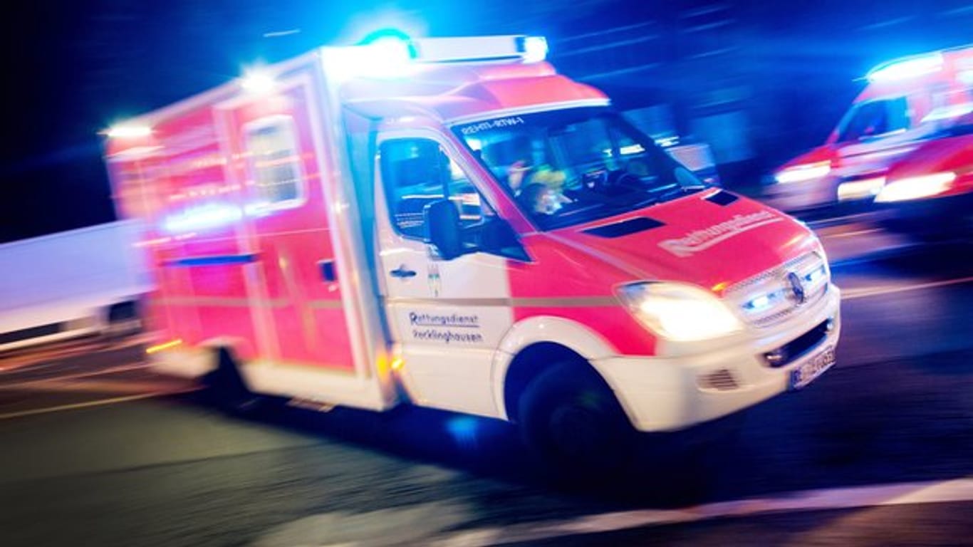 Ein Rettungswagen der Feuerwehr mit Blaulicht bei einem Einsatz.