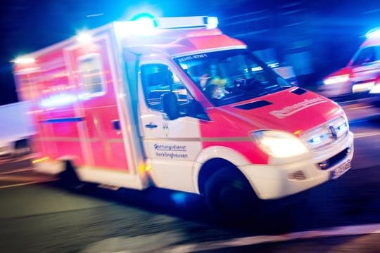 Ein Rettungswagen der Feuerwehr mit Blaulicht bei einem Einsatz.