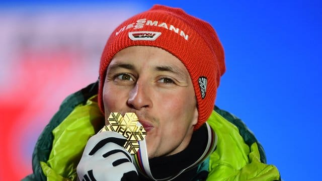 Bei der Siegerehrung küsst Eric Frenzel seine Goldmedaille.