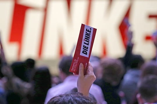 Delegierte der Linkspartei halten beim Parteitag in Bonn ihre Stimmkarte in die Luft.
