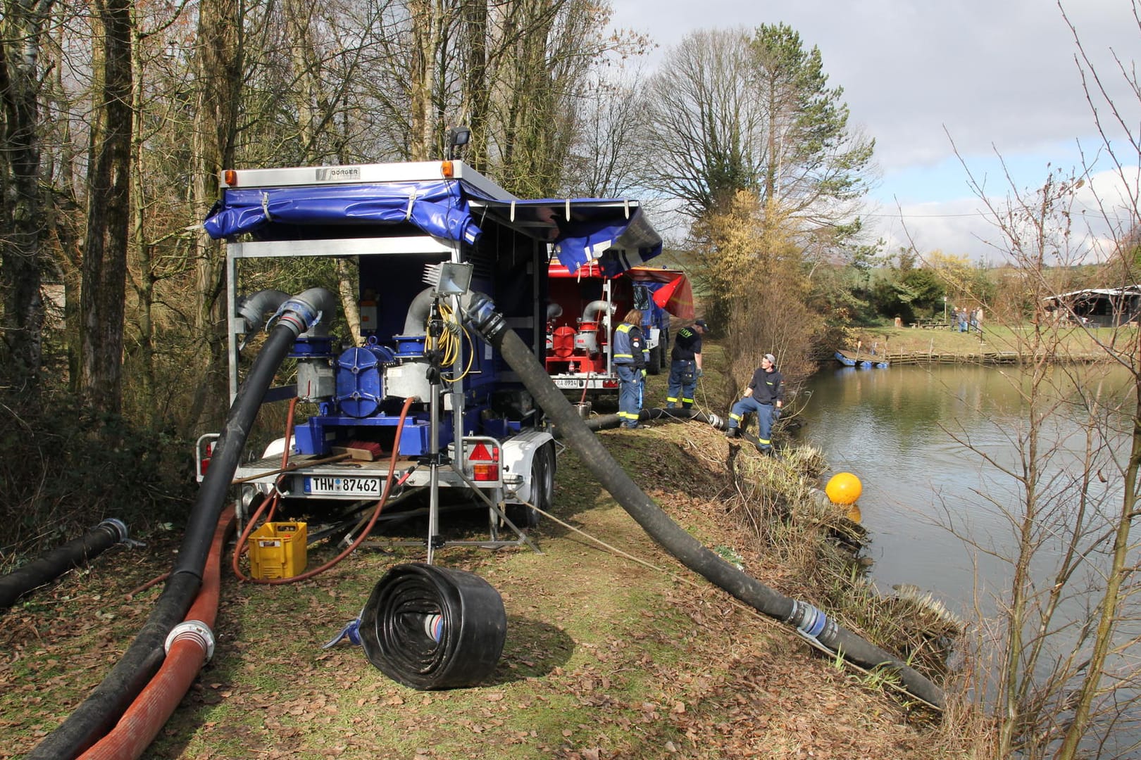 Dammbruch abgewendet: Einsatzkräfte von Feuerwehr und Technischem Hilfswerk (THW) pumpen Wasser aus einem Löschteich.