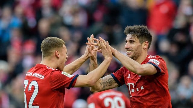 Bayerns Joshua Kimmich (l) gratuliert Javi Martínez zum Treffer gegen Hertha BSC.