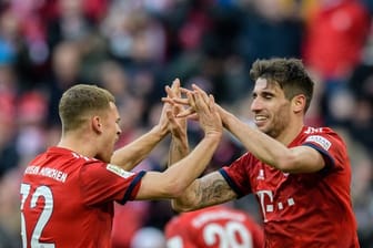 Bayerns Joshua Kimmich (l) gratuliert Javi Martínez zum Treffer gegen Hertha BSC.