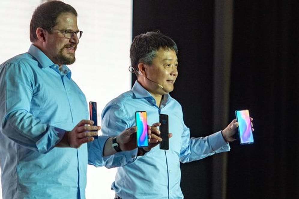 Xiaomi-Manager Xian Wang (r) und Christiano Amon vom Chipkonzern Qualcomm präsentieren das Xiaomi-Smartphone Mi Mix 3 5G beim Mobile World Congress in Barcelona.