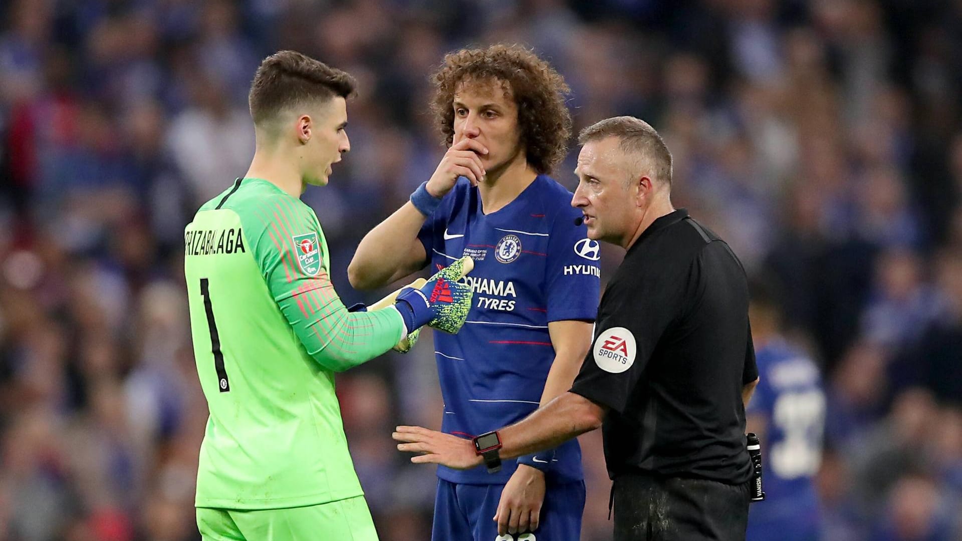 Kepa Arrizabalaga spricht mit Schiedsrichter Jon Moss und seinem Teamkollegen David Luiz über seinen Verbleib auf dem Platz.