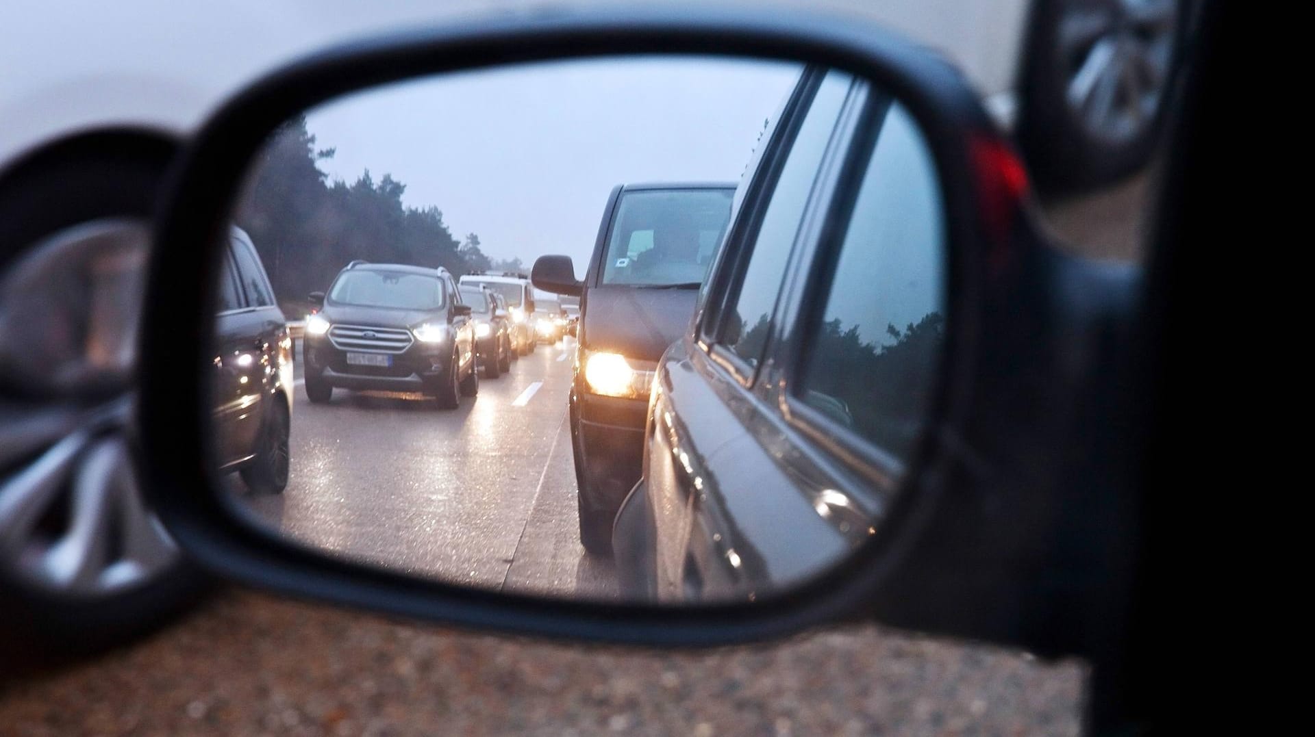 Blick in den Rueckspiegel bei Stau auf der Autobahn: Einige Autos mussten aufgrund der verlorenen Reifendecke abgeschleppt werden.