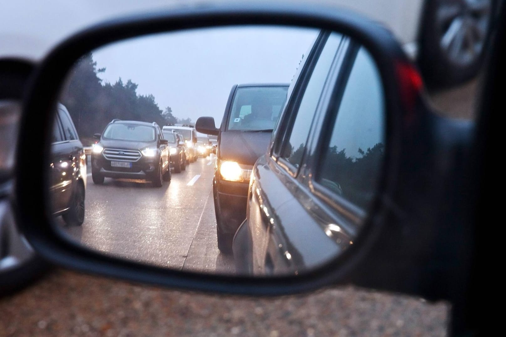 Blick in den Rueckspiegel bei Stau auf der Autobahn: Einige Autos mussten aufgrund der verlorenen Reifendecke abgeschleppt werden.