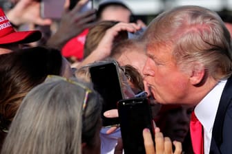 First Kiss: US-Präsident Trump beugt sich bei einer Veranstaltung in Tennessee mit Kussmund zu Anhängern hinüber.