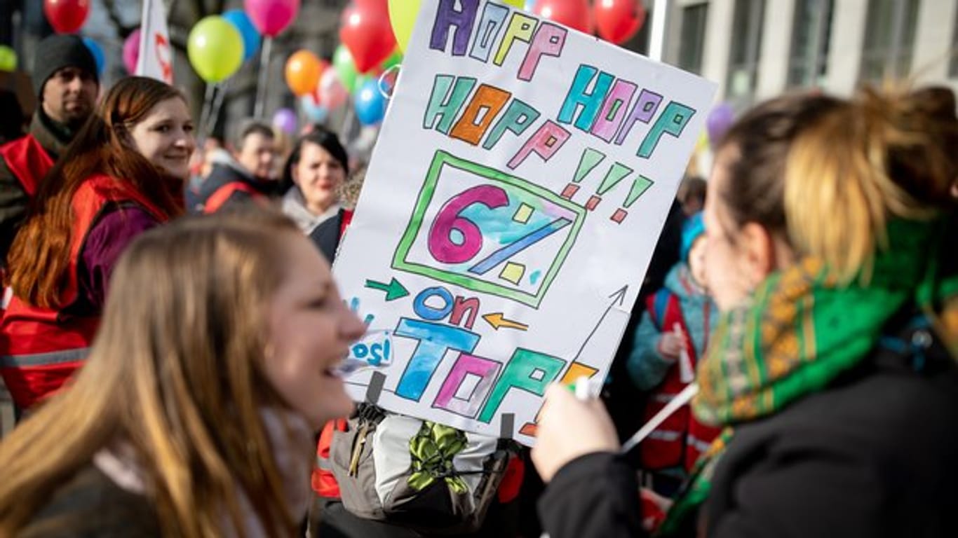 Mit Plakaten und Luftballons demonstrieren Lehrer und Erzieher in Berlin für mehr Gehalt.
