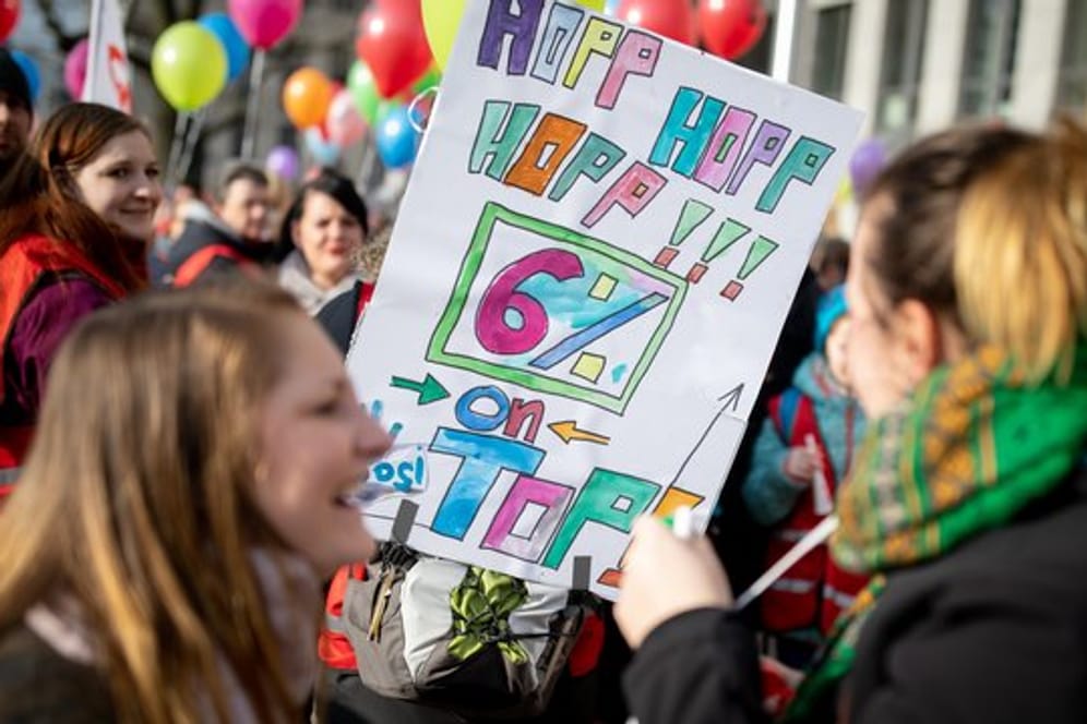 Mit Plakaten und Luftballons demonstrieren Lehrer und Erzieher in Berlin für mehr Gehalt.