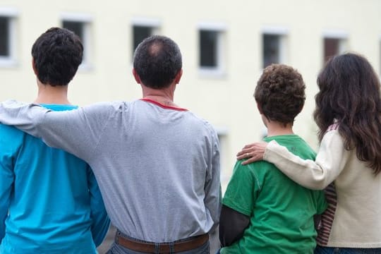 Eine syrische Familie sitzt vor einem Asylwohnheim im brandenburgischen Eisenhüttenstadt.