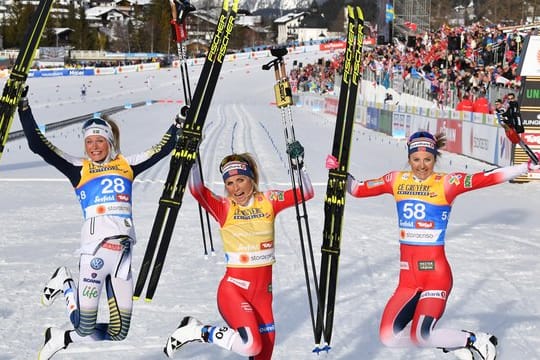 Therese Johaug (M) und Ingvild Flugstad Östberg (r) und Frida Karlsson feiern in Seefeld ihre Langlauf-Medaillen.