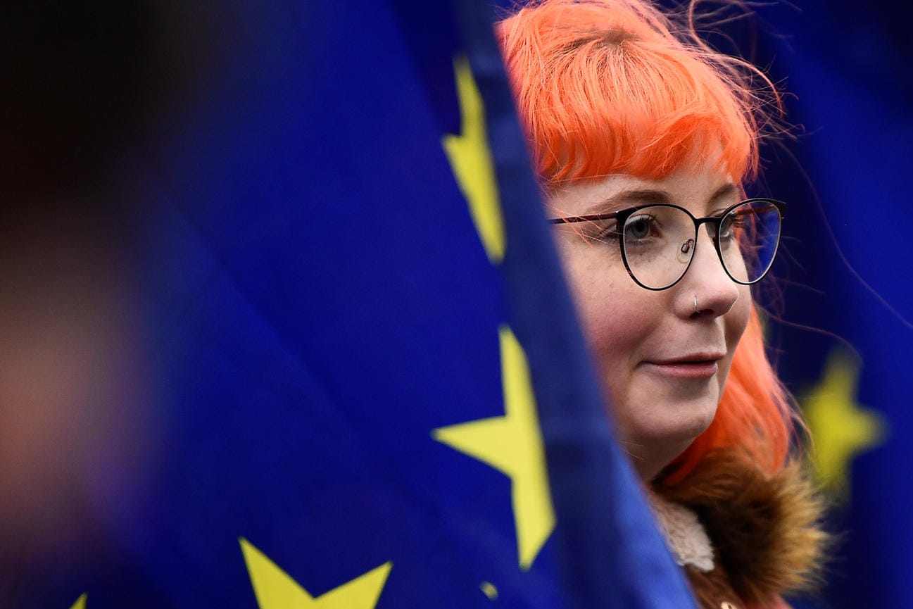 A protester stands among European Union flags outside the Houses of Parliament, after Prime Minister Theresa May's Brexit deal was rejected, in London