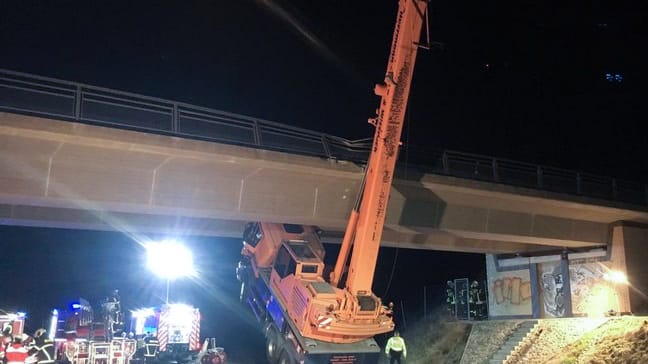 Ein Autokran ist mit ausgefahrenem Ausleger nahe der Autobahn-Anschlussstelle Holleben: Der Fahrer wurde bei dem Unfall schwer verletzt.