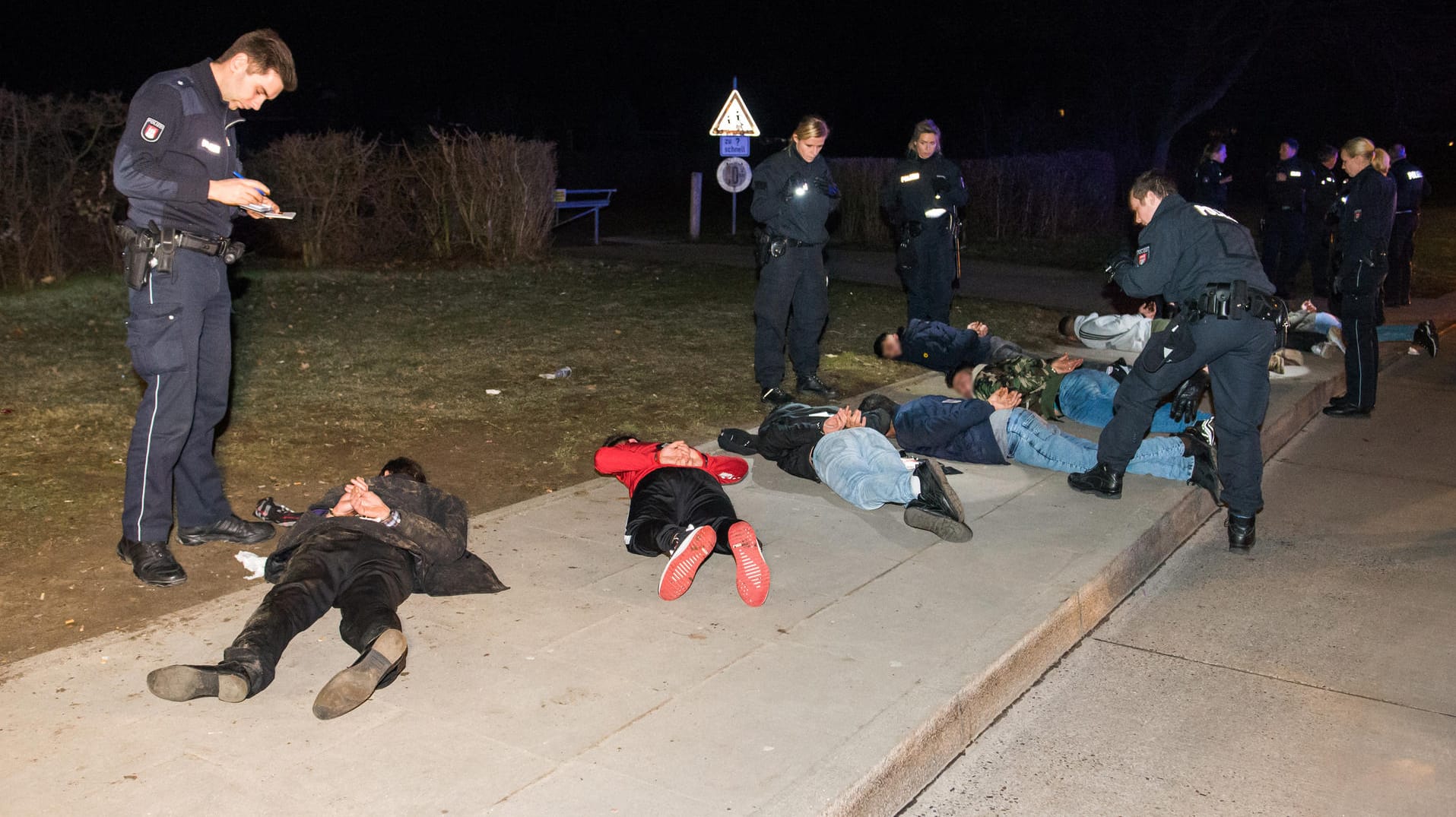 Zahlreiche festgenommene Personen liegen im Stadtteil Lohbrügge auf dem Gehweg: Die Polizei nahm etwa zehn Beteiligte vorläufig fest.