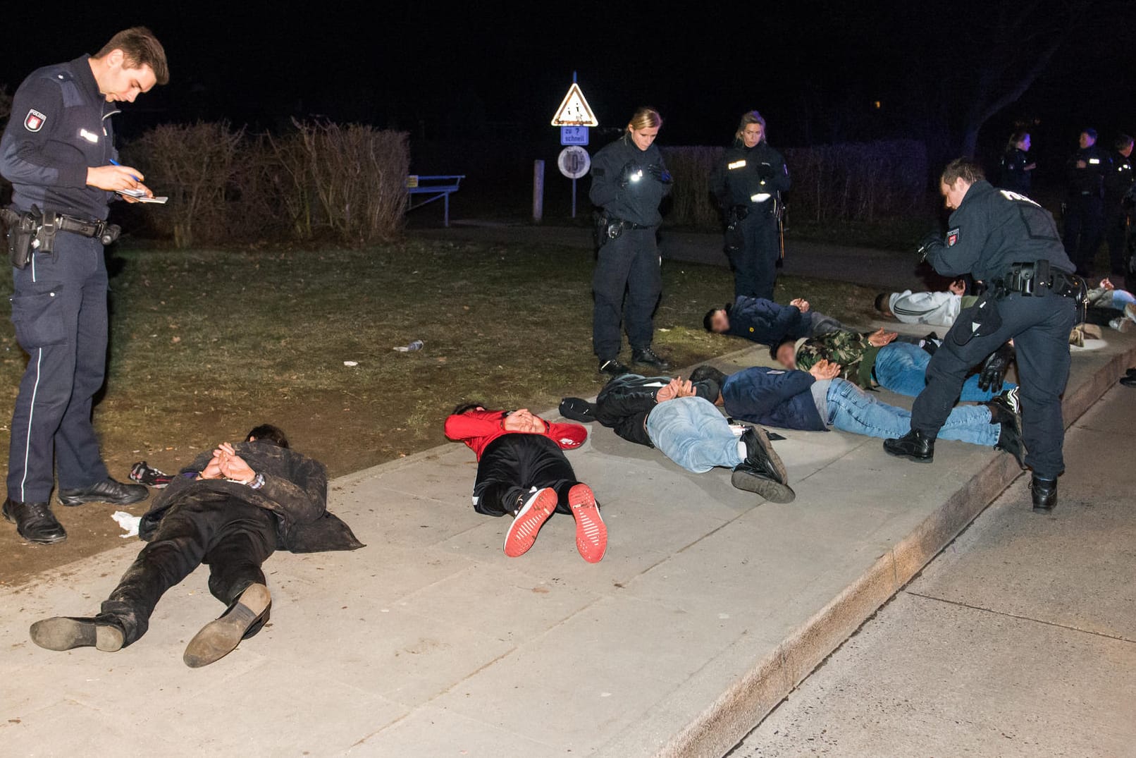 Zahlreiche festgenommene Personen liegen im Stadtteil Lohbrügge auf dem Gehweg: Die Polizei nahm etwa zehn Beteiligte vorläufig fest.