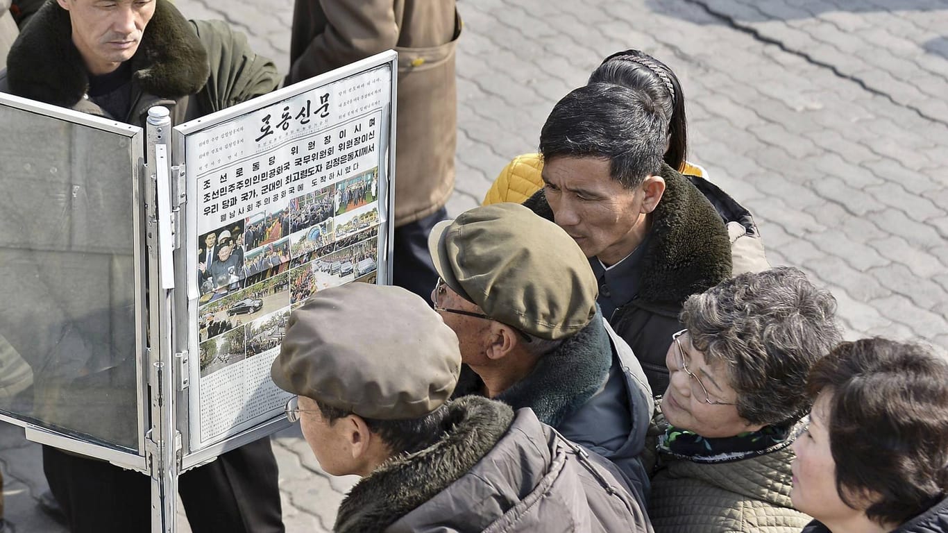 Nordkoreaner stehen vor einer Ausgabe der Staatszeitung: In anderen Fällen berichtet das Sprachrohr der Partei oft nur verzögert.