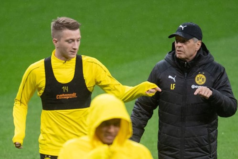 Dortmunds Trainer Lucien Favre (hinten r) spricht beim Training mit Marco Reus.