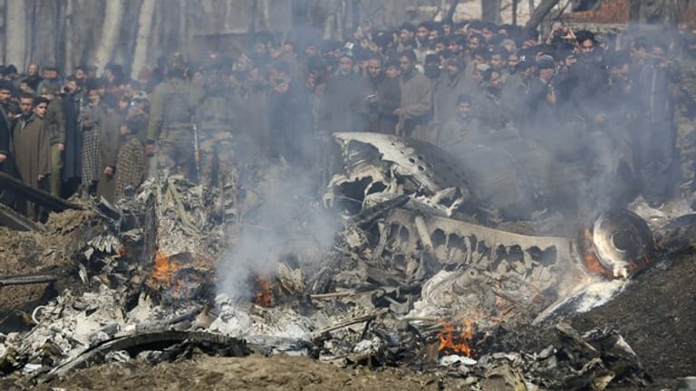 Kaschmirische Dorfbewohner versammeln sich bei den Trümmern eines indischen Kampfflugzeuge im Bezirk Budgam im indischen Teil Kaschmirs.