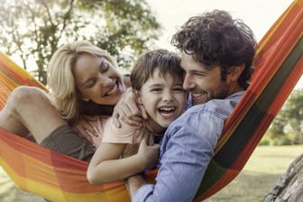 Familie in Hängematte: Der neue Feiertag in Thüringen soll Familien mehr gemeinsame Zeit ermöglichen.