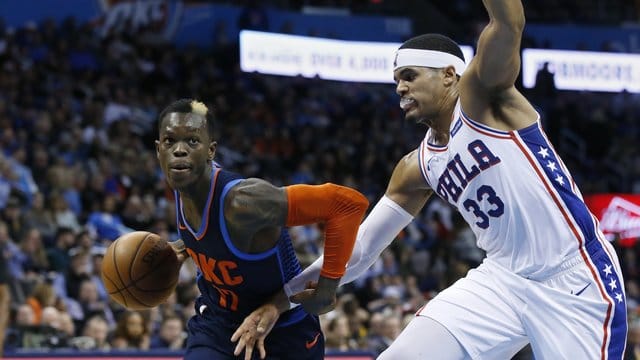 Thunder-Guard Dennis Schröder (l) behauptet sich mit dem Ball gegen Tobias Harris von den und Philadelphia 76ers.