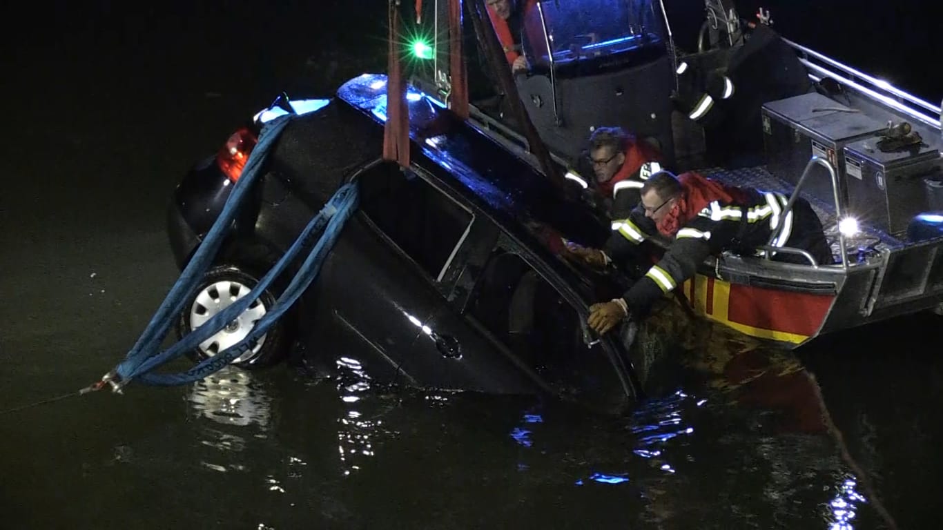 Remagen: Nach der Rettung des Fahrers bergen Feuerwehrleute das Fahrzeug aus dem Rhein.