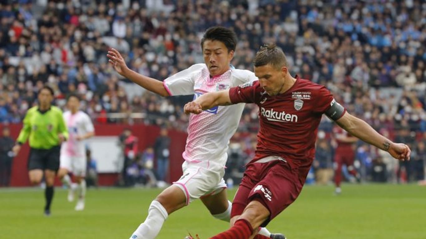 Vissel Kobes Lukas Podolski (r) im Duell um den Ball gegen einen Spieler von Sagan Tosu.