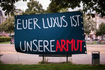 Ein Plakat mit der Aufschrift "Euer Luxus ist unsere Armut" in Berlin.
